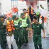 Lực lượng bộ đội tỉnh Trà Vinh hướng dẫn, giúp đỡ dân di tản về đất liền. (Ảnh: Phúc Sơn/TTXVN)