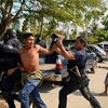 Cảnh sát địa phương bắt giữ những đối tượng gây bạo loạn tại Acapulco, bang Guerrero, Mexico. (Nguồn: AFP/TTXVN)