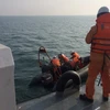 Lực lượng cứu hộ đưa thi thể lên tàu. (Ảnh: Hoàng Ngọc/TTXVN)