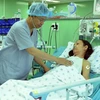 Phó giáo sư-tiến sỹ, bác sỹ Nguyễn Hoàng Định thăm khám cho bệnh nhân sau khi phẫu thuật thay van tim bằng kỹ thuật Ozaki. (Ảnh: Phương Vy/TTXVN)