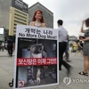 Một nhà hoạt động cầm biểu ngữ kêu gọi người dân Hàn Quốc dừng ăn thịt chó. (Nguồn: Yonhap)