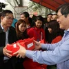 Phó Bí thư Thường trực tỉnh ủy Hải Dương Vũ Văn Sơn phát ngũ cốc cho các đại biểu và nhân dân. (Ảnh: Mạnh Minh/TTXVN)