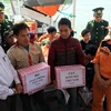 Đại diện Cục Hàng hải Việt Nam và Bộ Giao thông vận tải tặng quà cho các ngư dân sau khi lên bờ an toàn. (Ảnh: Tá Chuyên/TTXVN)