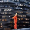 Công nhân vận chuyển thép cuộn tại một chợ thép ở Qingdao, tỉnh Sơn Đông, Trung Quốc. (Nguồn: AFP/TTXVN)