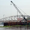 Thi công mới cầu sắt Bình Lợi để nâng tĩnh không thông thuyền của cầu hiện nay từ 1,5m lên 7m. (Ảnh: Huy Hùng/TTXVN)