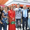 Đại sứ Nguyễn Hoài Dương và Phu nhân chụp ảnh với các bạn trẻ Mexico trước gian hàng Việt Nam. (Ảnh: Việt Hùng/Vietnam+)