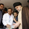 Thủ lĩnh cộng đồng người Hồi giáo dòng Shiite Moqtada al-Sadr (giữa, phải) bỏ phiếu tại điểm bầu cử ở thành phố Najaf ngày. (Nguồn: AFP/TTXVN)