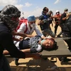 Chuyển người biểu tình Palestine bị thương sau các cuộc đụng độ với binh sỹ Israel tại khu vực biên giới Dải Gaza với Israel. (Nguồn: AFP/TTXVN)