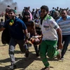 Chuyển người biểu tình Palestine bị thương sau các cuộc đụng độ với binh sỹ Israel tại khu vực biên giới Dải Gaza với Israel. (Nguồn: THX/TTXVN)