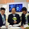 Ông Lý Ngọc Minh (đứng giữa) giới thiệu sản phẩm gốm sứ Minh Long I tại Triển lãm Ambiente - hội chợ thương mại về ngành sứ lớn nhất châu Âu. (Ảnh: TTXVN phát)