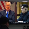 Người dân theo dõi qua truyền hình hình ảnh Tổng thống Mỹ Donald Trump (trái) và Nhà lãnh đạo Triều Tiên Kim Jong-un. (Nguồn: AFP/TTXVN)