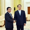 Bí thư Trung ương Đảng Nguyễn Xuân Thắng và ông Trần Hy bắt tay thân mật. (Ảnh: Lương Tuấn/Vietnam+)