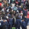 Cảnh sát Pháp đưa những người tị nạn tới nơi ở tạm thời sau khi giải tỏa khu trại tạm Millenaire ở thủ đô Paris. (Nguồn: AFP/TTXVN)