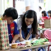 Các bạn trẻ tham gia Chương trình Trại hè Việt Nam 2018thăm và tặng quà Trung tâm Nuôi dưỡng trẻ mồ côi tỉnh Quảng Nam ở thành phố Hội An. (Ảnh: Đỗ Văn Tưởng/TTXVN)