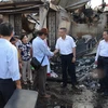 Đại sứ Vũ Quang Minh (thứ hai từ phải sang) đến thị sát và thăm hỏi kiều bào sau vụ cháy. (Ảnh: Nhóm PV TTXVN thường trú tại Campuchia)