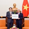 Đại diện Bộ Ngoại giao đã trao cho Đại sứ Nhật Bản tại Việt Nam khoản hỗ trợ. (Ảnh: TTXVN phát)