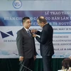 Ông Vincent Floreani gắn Huân chương Cành cọ Hàn lâm cho phó giáo sư-tiến sỹ Nguyễn Ngọc Điện. (Ảnh: Thu Hoài/TTXVN)