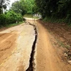 Đoạn đường bị nứt và sụt lún 70-80cm, dài gần 100m, nguy cơ sạt lở nghiêm trọng. (Ảnh: Quang Quyết/TTXVN)
