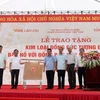 Lãnh đạo tỉnh Lào Cai và Tập đoàn Công nghiệp Than-Khoáng sản Việt Nam (bên phải) trao tấm đồng tượng trưng cho lãnh đạo tỉnh Sơn La (bên trái). (Ảnh: Quốc Khánh/TTXVN)