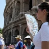 Khách du lịch thăm quan đấu trường cổ La Mã tại Rome trong ngày nắng nóng. (Nguồn: AFP/TTXVN) 