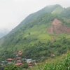 Bản Pơ Nang, xã Tân Hợp nằm dưới một dãy núi lớn và có nguy cơ sạt trượt cao. (Ảnh: Hữu Quyết/TTXVN)