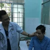 Bác sỹ thăm khám cho binh nhì Lê Hữu Thắng. (Ảnh: Đinh Hằng/TTXVN)