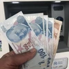 Kiểm tiền lira tại Istanbul, Thổ Nhĩ Kỳ. (Nguồn: THX/TTXVN)
