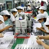 Công nhân làm việc trên dây chuyền sản xuất động cơ siêu nhỏ tại nhà máy ở Hoài Bắc, An Huy, Trung Quốc. (Nguồn: AFP/TTXVN)