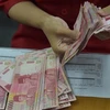 Nhân viên phòng giao dịch hối đoái kiểm tiền giấy rupiah tại thủ đô Jakarta, Indonesia. (Nguồn: AFP/TTXVN)