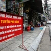 Bất chấp biển cấm buôn bán dưới lòng đường, hè phố ngay sát, nhiều cửa hàng vẫn ngang nhiên bày bàn ghế lấn chiếm vỉa hè. (Ảnh: Phú Quang/Vietnam+)