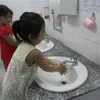 Hướng dẫn trẻ rửa sạch tay trước khi ăn và sau khi vệ sinh tại Trường mầm non phường 1, quận 10. (Ảnh: Đinh Hằng/TTXVN)