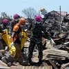 Lực lượng cứu hộ chuyển thi thể nạn nhân ra khỏi đống đổ nát sau thảm họa động đất và sóng thần ở Palu. (Nguồn: THX/TTXVN)