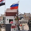 Cờ Syria (trái) và cờ Nga tại khu vực Abu Duhur, tỉnh Idlib. (Nguồn: AFP/TTXVN)