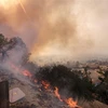 Lửa cháy rừng bốc ngùn ngụt gần tuyến đường cao tốc ở thung lũng Simi, bang California, Mỹ. (Nguồn: THX/TTXVN)
