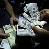 Giao dịch đổi đồng Rials của Iran và đồng đôla Mỹ ở thủ đô Tehran, Iran. (Nguồn: AFP/TTXVN)