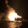 Tàu cá QNa 91775 TS của ông Ngô Văn Cát đang neo đậu trong bến Long Thạnh Đông bùng phát cháy dữ dội. (Ảnh: Đoàn Hữu Trung/TTXVN)