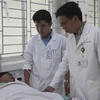 Bác sỹ Trần Viết Bảo và bác sỹ Nguyễn Huy Phú (ngoài cùng) đã hiến máu trong ca mổ để cứu sống bệnh nhân nguy kịch do mất nhiều máu. (Ảnh: Lê Xuân/TTXVN)