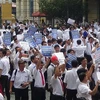 Hàng trăm tài xế taxi Vinasun cầm theo băng rôn, biểu ngữ đến dự phiên tòa. (Ảnh: Thành Chung/TTXVN)