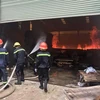 Lực lượng Cảnh sát phòng cháy chữa cháy tỉnh Bình Dương nỗ lực phun nước dập tắt đám cháy. (Ảnh: Huyền Trang/TTXVN)
