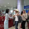 Các du khách Nga nhận món quà chiếc nón lá Việt Nam. (Ảnh: Tiên Minh/TTXVN)