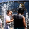 Trẻ em tránh nóng tại vòi phun nước ở Melbourne, Australia, ngày 24/1. (Nguồn: AFP/TTXVN)