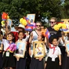 Khách nước ngoài chụp ảnh lưu niệm với các em học sinh Việt kiều tham gia đón đoàn. (Ảnh: Minh Hưng/TTXVN)