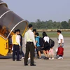 Những hành khách đầu tiên bay chuyến Cần Thơ-Đà Nẵng của Vietnam Airlines. (Ảnh: Thanh Liêm/TTXVN)