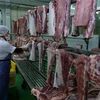 Phân loại thịt lợn đã chế biến và treo trên giá đảm bảo an toàn vệ sinh thực phẩm. (Ảnh: Vũ Sinh/TTXVN)