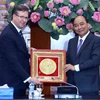 Thủ tướng Nguyễn Xuân Phúc tặng quà cho ông Alexander C. Feldmen, Chủ tịch, kiêm Tổng giám dốc điều hành Hội đồng kinh doanh Hoa Kỳ-ASEAN. (Ảnh: Thống Nhất/TTXVN)