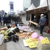 Các công nhân đang tháo dỡ, di dời các di ảnh khỏi địa điểm biểu tình tại quảng trường Gwanghwamun. (Nguồn: Yonhap)