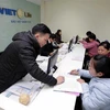 Hướng dẫn khách hàng làm thủ tục bảo hiểm tại Bảo Việt Nhân thọ Cao Bằng. (Ảnh: Trần Việt/TTXVN)