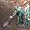 Lực lượng công binh xử lý quả bom được tìm thấy trong khu vực Trường Trung học phổ thông Cửa Tùng. (Ảnh: Nguyên Lý/TTXVN)