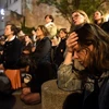 Người dân cầu nguyện khi chứng kiến vụ hỏa hoạn tại Nhà thờ Đức Bà ở Paris, Pháp. (Nguồn: AFP/TTXVN)