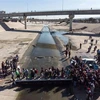 Người di cư Trung Mỹ qua sông Tijuana để tới cửa khẩu El Chaparral ở Tijuana, bang Baja California, Mexico, gần biên giới Mỹ-Mexico. (Nguồn: AFP/TTXVN)